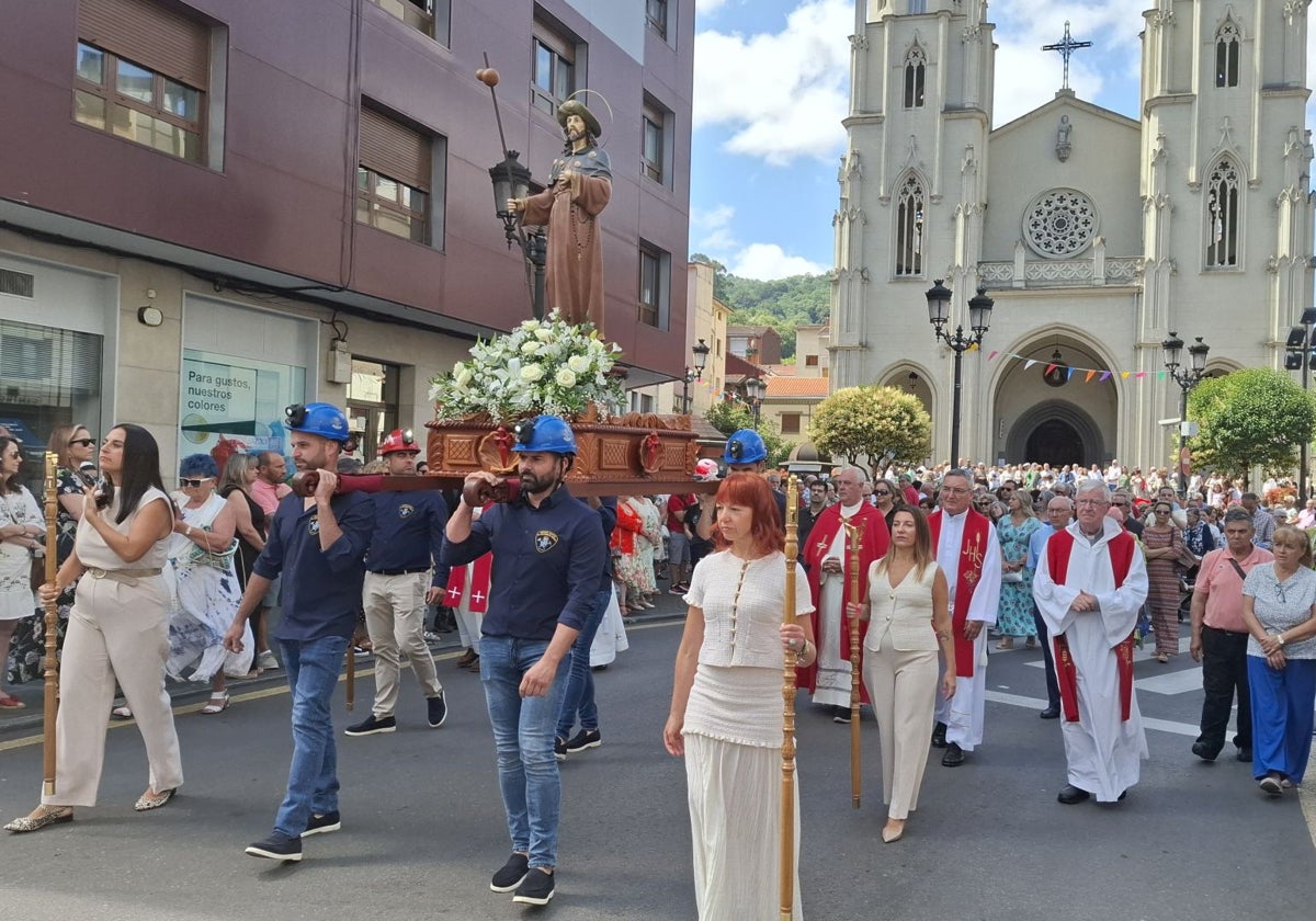 Procesión, con la imagen de Santiago, portada por la Brigada de Salvamento Minero, a la salida de la iglesia de Sama.
