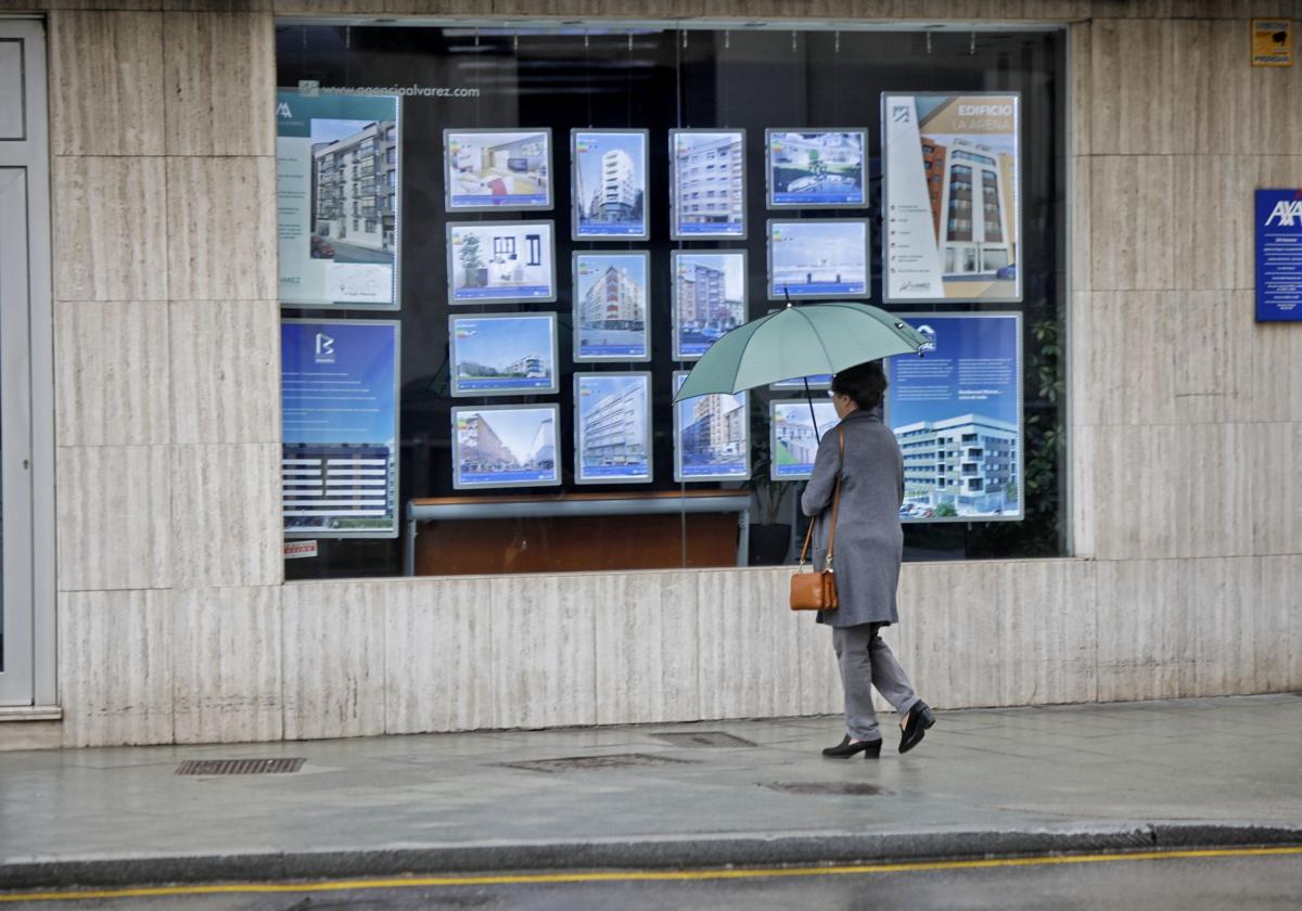Una mujer frente a una inmobiliaria.