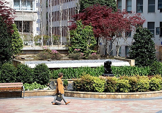 Una mujer pasa por delante de la fuente de la plaza de Longoria Carbajal.