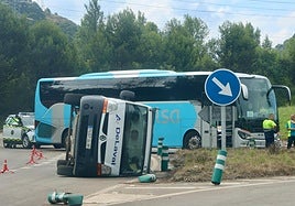  Furgoneta volcada y autobús detenido con el que colisionó en la rotonda de Aboño esta mañana.