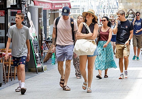 Turistas caminando ayer por Gijón.