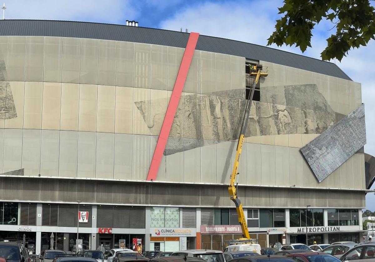 Operarios actúan desde una grúa en las tareas de limpieza y saneado de la estructura portante de la fachada este de El Molinón.