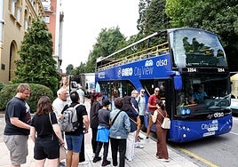 Usuarios haciendo cola para subir al bus turístico.