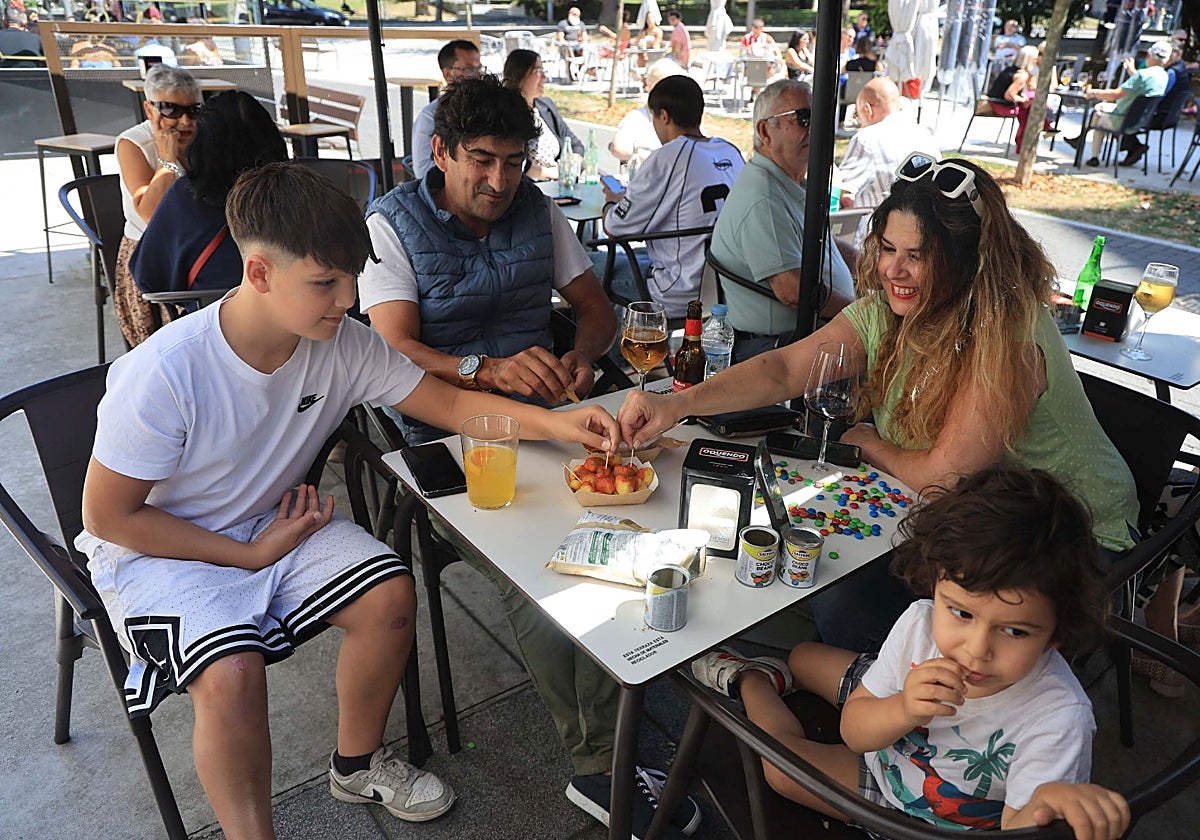 Esther Pérez junto a sus hijos Ávaro y Alejandro y su pareja José Ramón disfrutando de unas tapas en una terraza del Carbayedo, en Avilés.