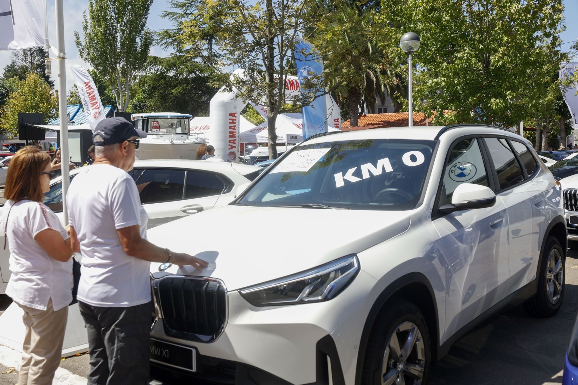 Dos personas ante un coche kilómetro cero en la Feria.