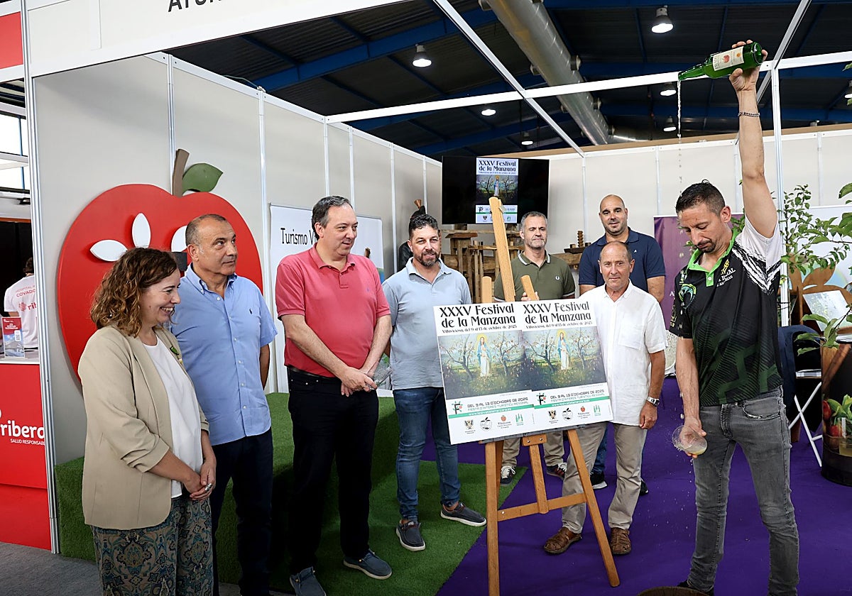Andrés Menéndez escancia un culín ante Rocío Vega, Jorge García, Alejandro Vega, José Luis Piñera, Gustavo Costales, Daniel Ruiz y, junto al cartel del Festival de la Manzana, Luis Repiso, en la Fidma