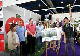 Andrés Menéndez escancia un culín ante Rocío Vega, Jorge García, Alejandro Vega, José Luis Piñera, Gustavo Costales, Daniel Ruiz y, junto al cartel del Festival de la Manzana, Luis Repiso, en la Fidma