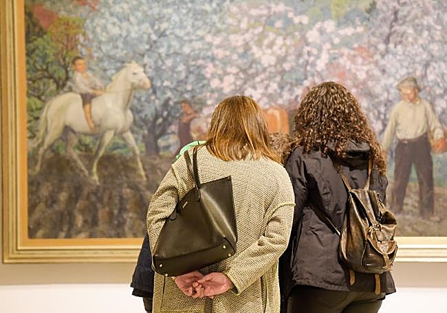 Arte gijonés al cuadrado. Dos visitantes disfrutan de una de las obras del pintor gijonés Nicanor Piñole en su museo homónimo.