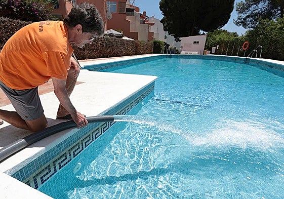 Un hombre llena una piscina de agua.