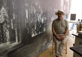 José Juan de Blas posa en su estand como sus antepasados retratados en la pared.