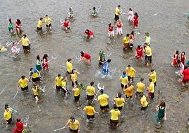 'Tritones' dándose un baño en el río tras el desfile del día del Descenso del Sella.