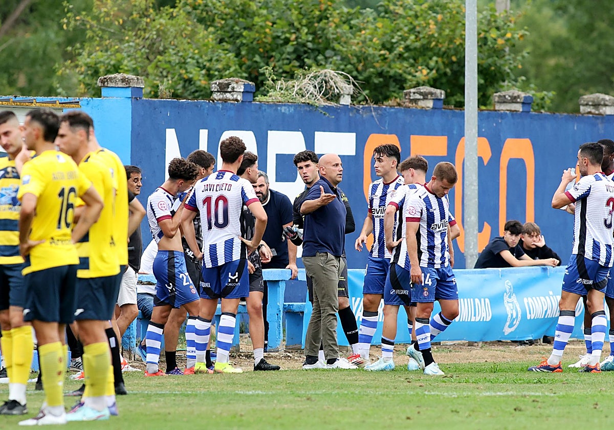 Javi Rozada corrige a sus jugadores en la pausa de hidratación en la primera mitad del partido del Real Avilés en Grado ante el Mosconia.