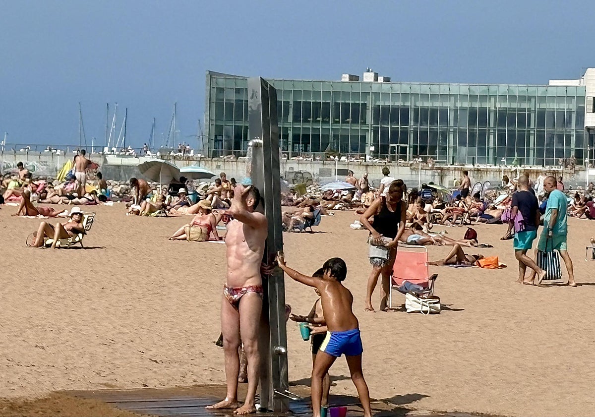 Imagen principal - Arriba, ambiente en la playa de Poniente de Gijón. En la imagen central, Manuel Blanco, que pasa estos días de vacaciones con su familia en Besullo (Cangas del Narcea), lanzándose la piscina del recién inaugurado hotel La Rectoral. Y, sobre estas líneas, Ángel e Irene Monge, y Daniel del Castillo, madrileños, ante el bar de Moal.