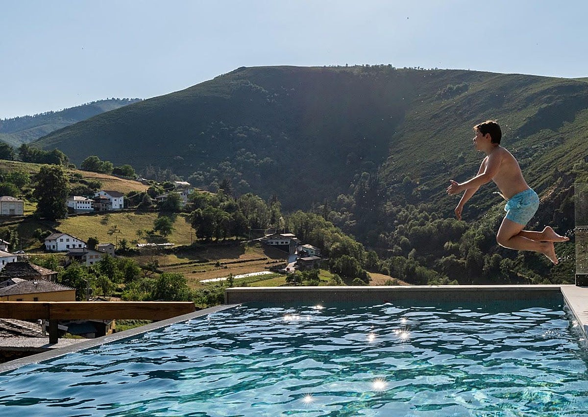 Imagen secundaria 1 - Arriba, ambiente en la playa de Poniente de Gijón. En la imagen central, Manuel Blanco, que pasa estos días de vacaciones con su familia en Besullo (Cangas del Narcea), lanzándose la piscina del recién inaugurado hotel La Rectoral. Y, sobre estas líneas, Ángel e Irene Monge, y Daniel del Castillo, madrileños, ante el bar de Moal.