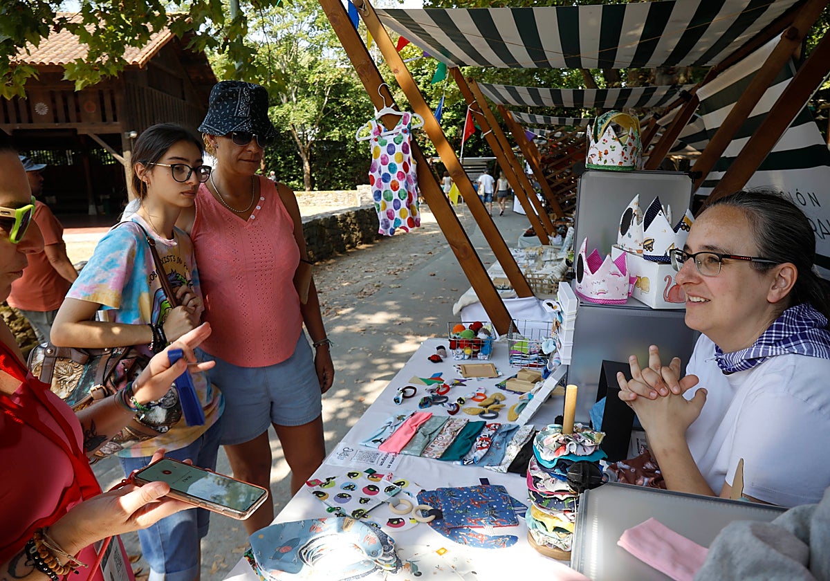 Una clienta le pregunta por un diseño de ropa a Aida Díaz.