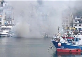 Una embarcación quemándose en el puerto de Luarca.