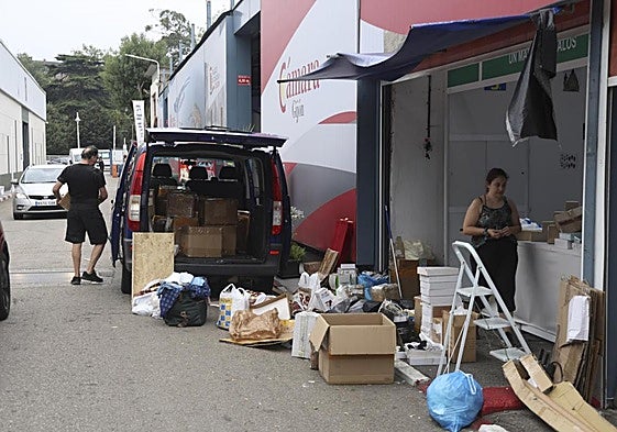 Uno de los expositores recoge su mercancía en cajas de cartón y bolsas.