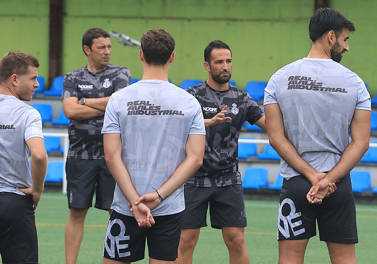 José Luis Deus, a la izquierda de Dani Vidal, con los brazos cruzados, durante su primer entrenamiento con el Real Avilés.