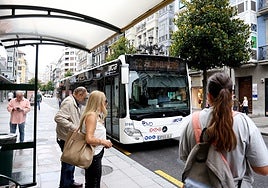 Usuarios en la parada de autobús de la calle Uría.