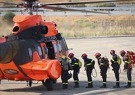 Efectivos de la Unidad Militar de Emergencia (UME) se disponen a acceder a uno de los helicópteros desplegados en la zona, en el centro de mando instalado en Astorga.