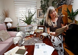 Flor Hevia muestra objetos históricos de Víctor Labrada con el cronista gijonés y su esposa Florinda Hevia en una foto enmarcada en la pared del fondo.