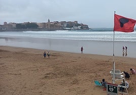 Bandera roja en San Lorenzo, en Gijón, esta tarde.