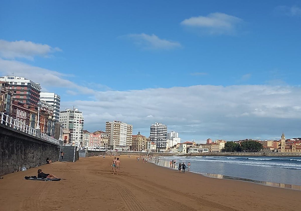 Momento en el que un socorrista iza esta mañana la bandera roja en la escalera 7 de la playa de San Lorenzo, en Gijón.