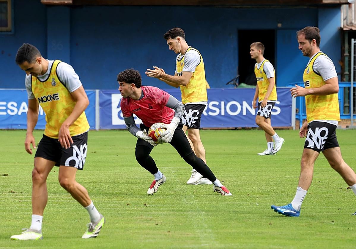 Álvaro atrapa un balón con Adri Gómez, Jose Martínez y Viti formando línea defensiva.