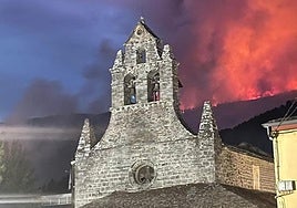 La iglesia de San Antolín de Ibias acorralada por el fuego el martes por la tarde.