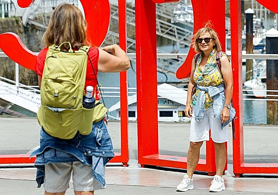 Una turista inmortaliza a su amiga ante las Letronas de Gijón.