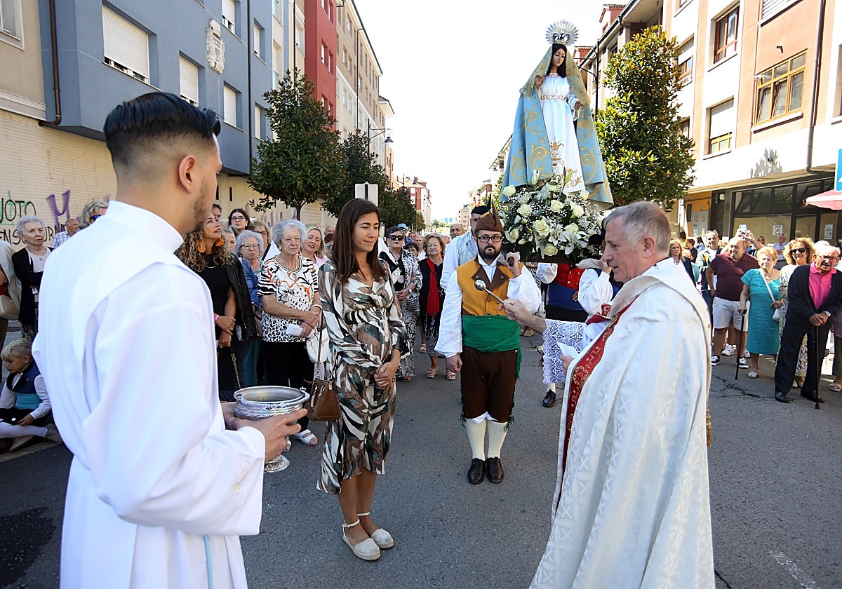 Bendición a una mujer embarazada ante las imágenes de la Virgen y Santa Isabel.