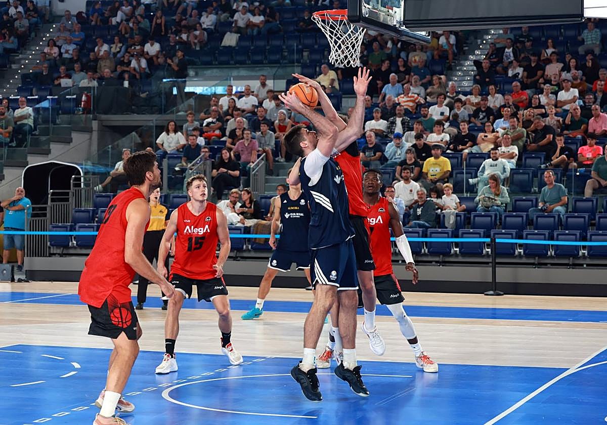 Alonso Faure salta a canasta ante el intento de tapón de la defensa rival.