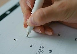 Una persona escribe en su agenda.