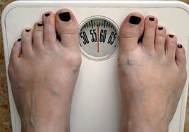 Una persona se pesa en una báscula.