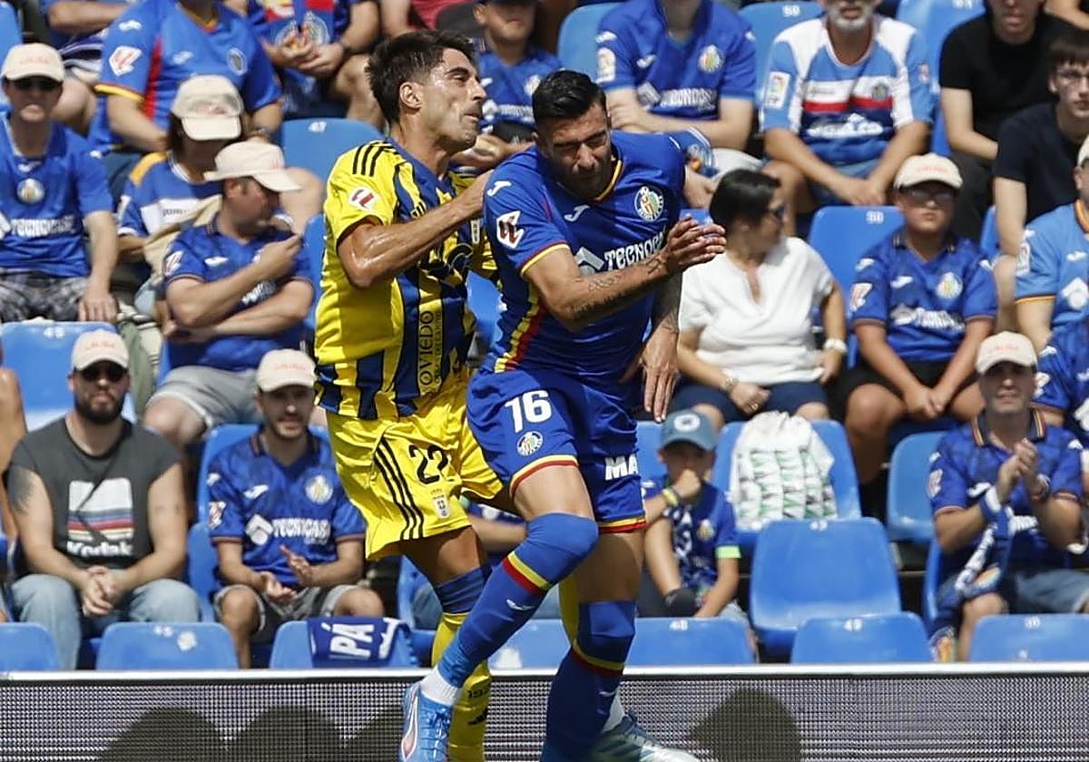 Duro choque entre el defensa del Getafe Diego Rico y Nacho Vidal, del Real Oviedo, durante el partido en el Coliseum.