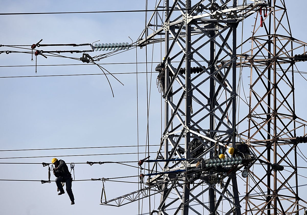 Operarios trabajando en una torre de alta tensión, en Gijón.