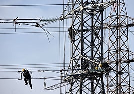 Operarios trabajando en una torre de alta tensión, en Gijón.