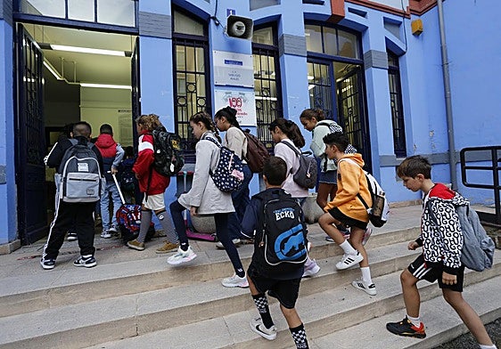 Alumnos entrando en un colegio en el primer día de clase.