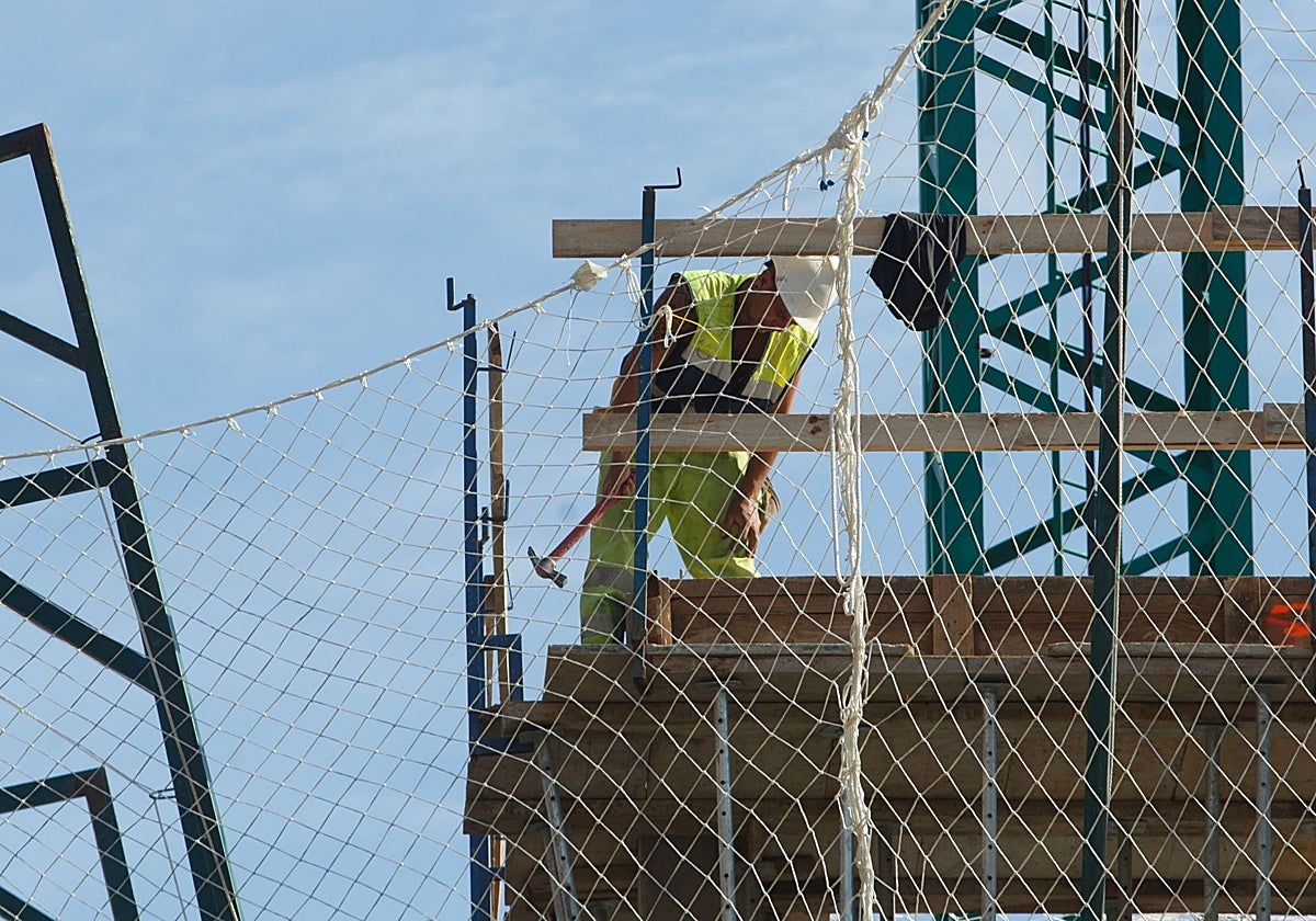 Un obrero trabajando en la construcción de un edificio para viviendas, en Avilés.