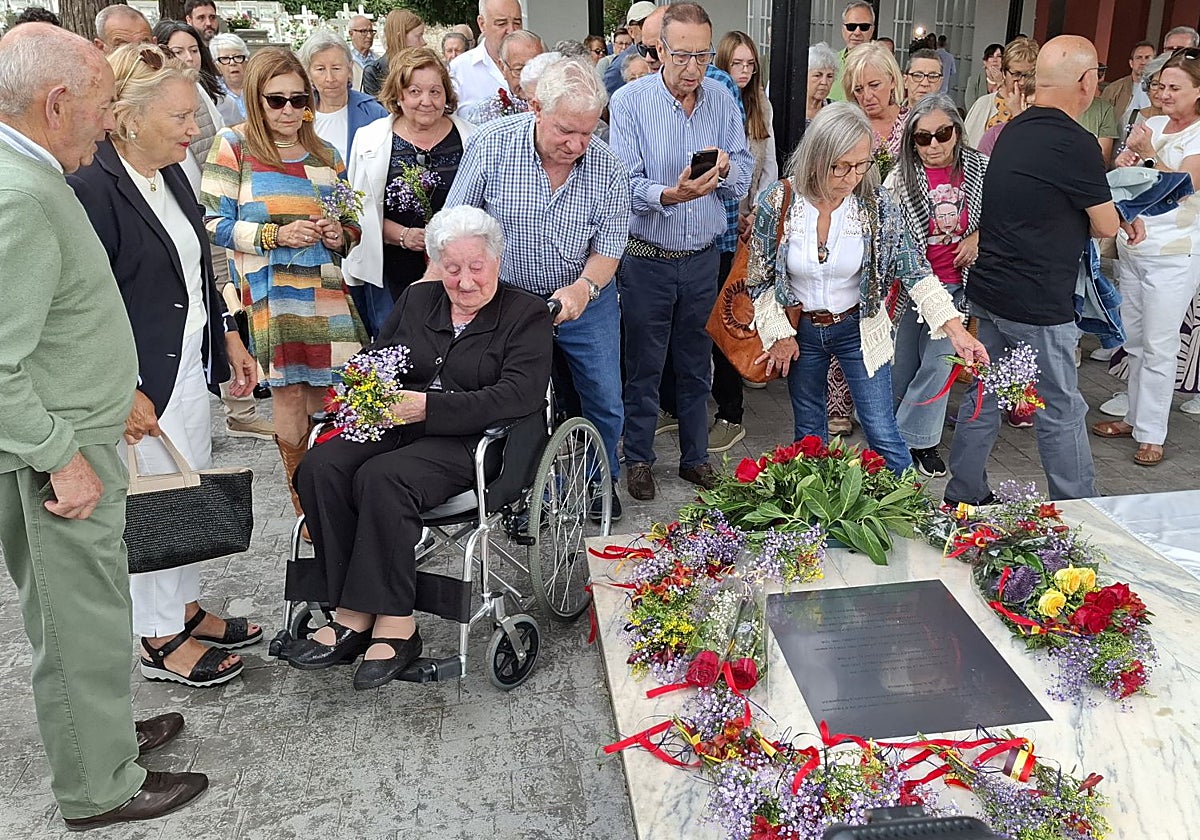 Los familiares de las víctimas de la fosa de La Garba dejan flores en los nichos reservados del cementerio municipal de Grado.