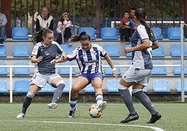 Laura Lobo pisa el balón entre dos jugadoras de la Real Sociedad B.