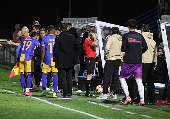 Natalio pide explicaciones al cuarto árbitro mientras el colegiado madrileño Fernando Bueno revisa la jugada del penalti que detiene Álvaro.