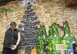 La hostelera Loreto García escanciando sidra en su local de Pola de Siero, El Madreñeru.