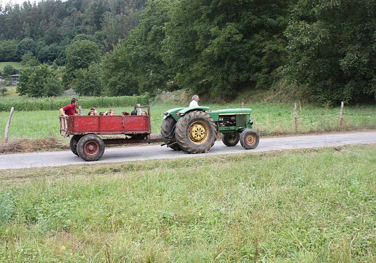 Un hombre conduce un tractor en el medio rural de Asturias.