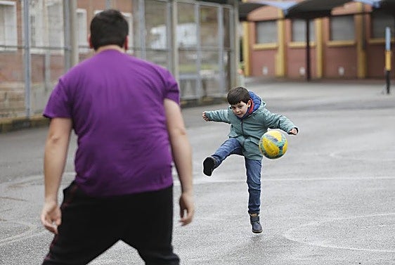Un niño juega al fútbol en el patio del colegio de Versalles, el curso pasado.