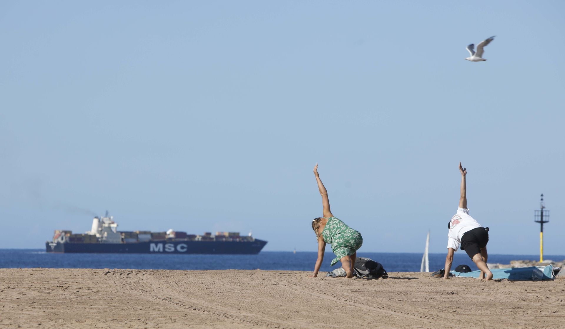 Un barco con contenedores, a su paso por delante de la playa de Poniente.