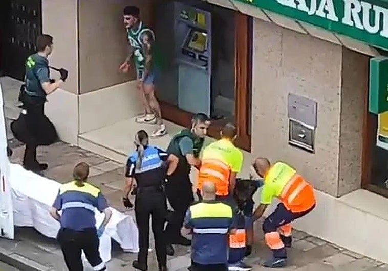 El atacante, muy agresivo, se encara con un agente mientras los sanitarios atienden a uno de los heridos.