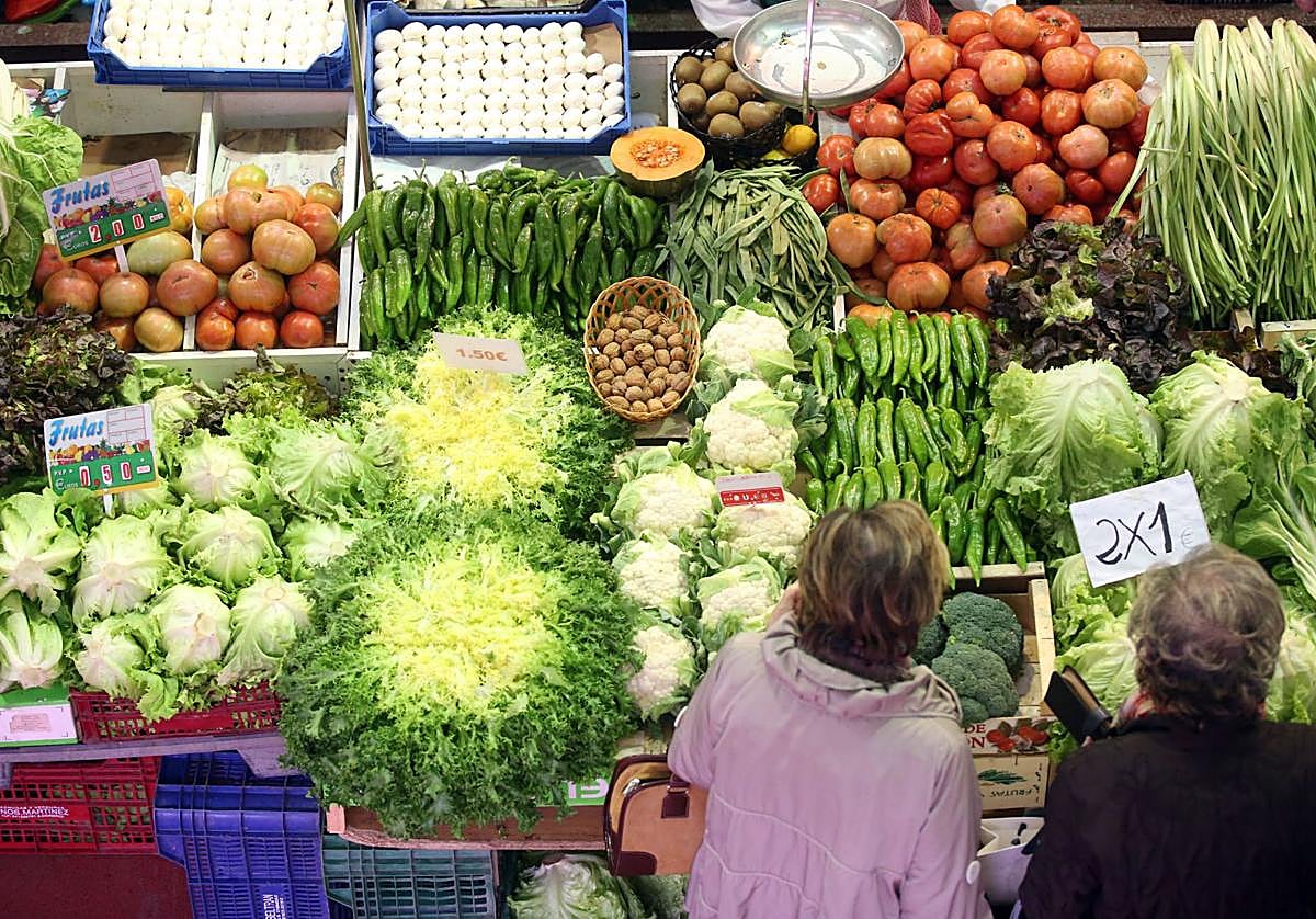 Dos mujeres compran frutas y verduras.
