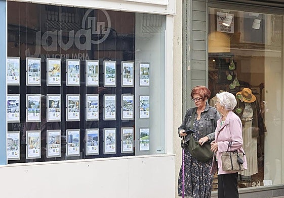 Dos mujeres pasan ante el escaparate de la inmobiliaria Java, en la calle Rui Pérez.