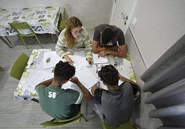 Una educadora trabaja con tres menores en un centro.